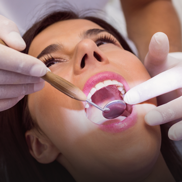 dentist examining patient teeth with mouth mirror