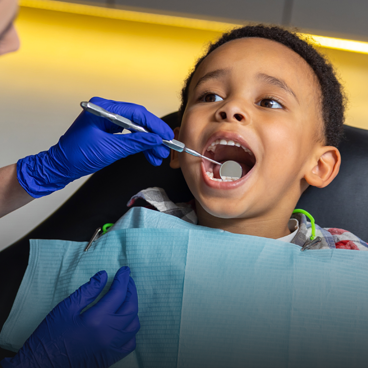 dentist examining patient teeth with mouth mirror