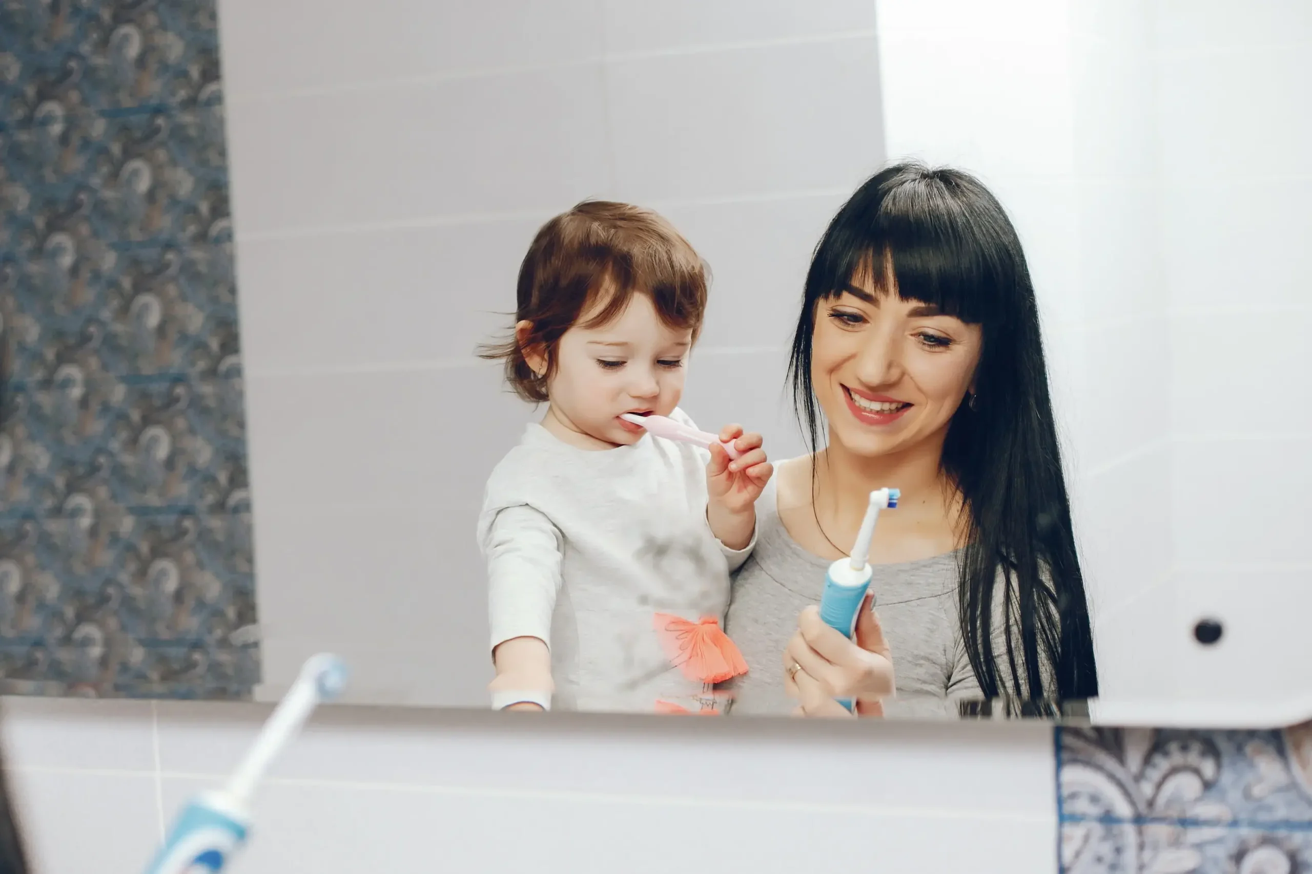 mother brushing her teeth with her child